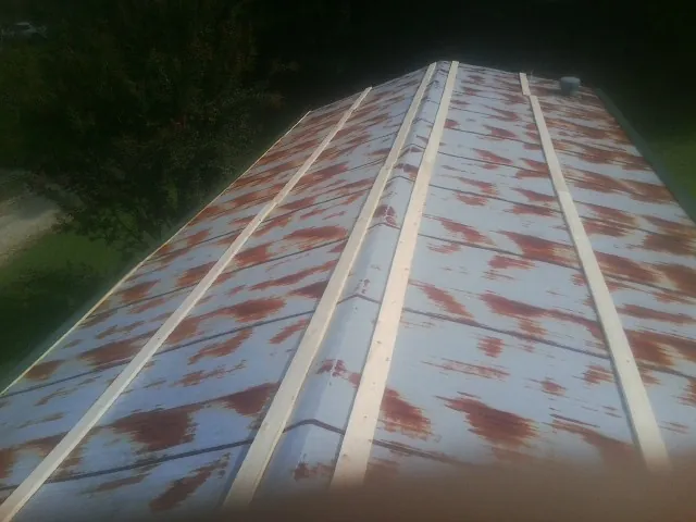 Rusted metal roof panels with new wood purlins before replacement — Storm Damage Roof Repair in Castroville by Roofing Brothers