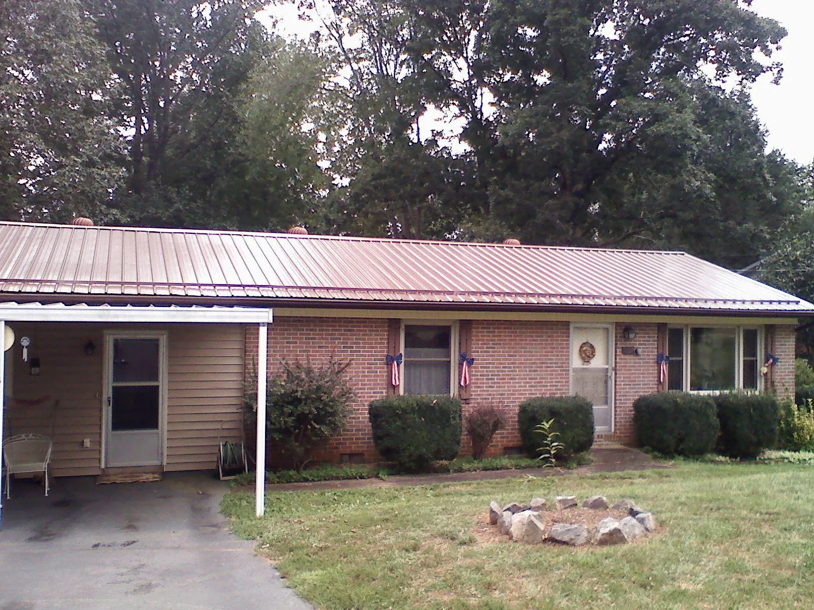 Bronze metal roof and carport on a brick ranch home — Roof Repair work by our crew in Castroville